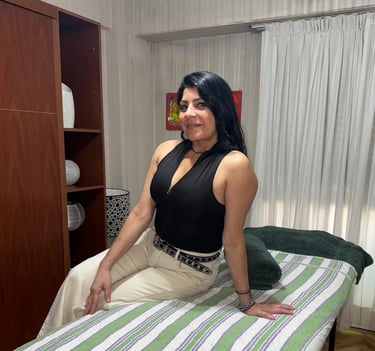 Camila, masajista profesional, posando sentada sobre la camilla en su consultorio de Caballito.