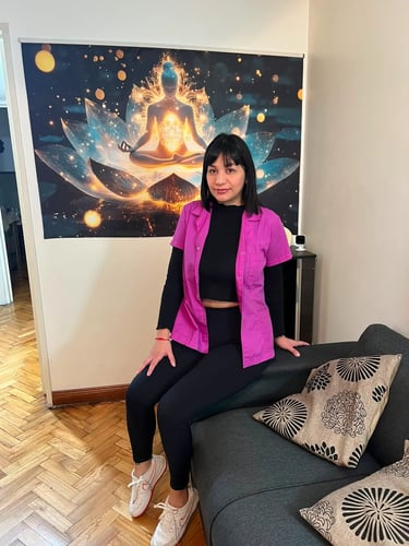 Mica, masajista independiente con chaqueta fucsia, junto al sillón en su espacio decorado de Caballito.