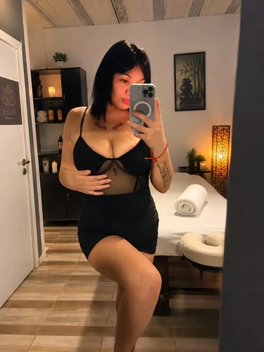 Selfie de la masajista Mica con vestido negro en el espejo de su gabinete privado en Caballito.