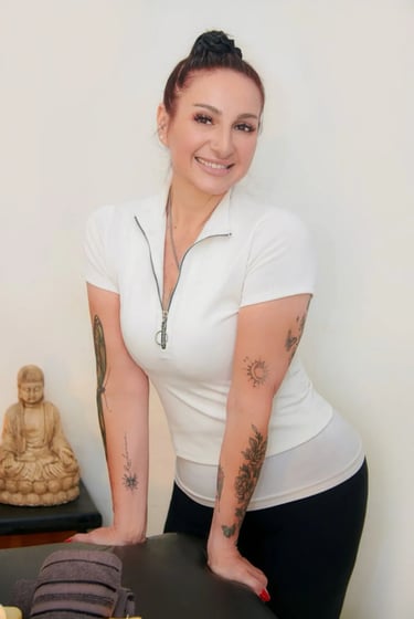 Retrato de la masajista profesional Esmeralda sonriendo junto a un buda decorativo en su gabinete de Congreso.