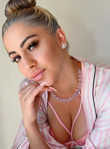 Primer plano sensual de la masajista Emilia con un sugerente conjunto rosa en su gabinete de Flores.