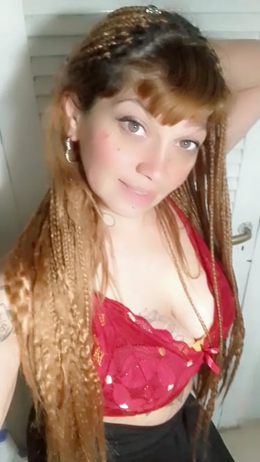 Gabinete privado de Paola masajista independiente en Ituzaingó, posando con top rojo.