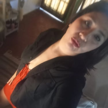 Gabinete privado de Rosa masajista independiente en Ituzaingó, vistiendo saco oscuro y prenda roja.
