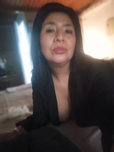 Rosa masajista sensual en Ituzaingó, selfie de frente luciendo blazer negro en su gabinete.