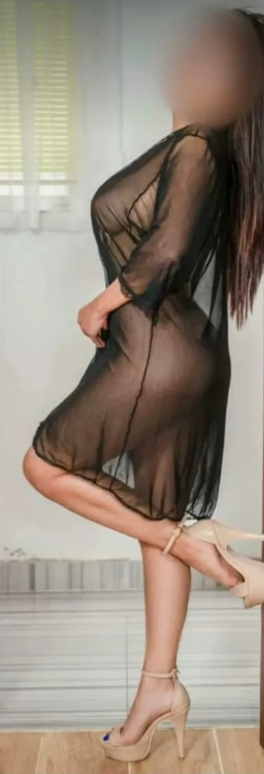 Gia luciendo de perfil un sensual vestido negro transparente con tacones en su gabinete de Palermo.