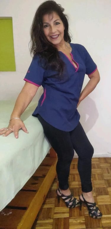 Masajista profesional Marisol posando con ambo azul y detalles rosas en su consultorio de Microcentro.