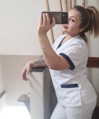 Analía con uniforme blanco de masajista en un espacio acondicionado para masajes en Pilar.