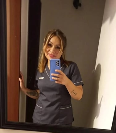 Analía posando con ambo azul frente al espejo en su consultorio privado de masajes en Pilar.
