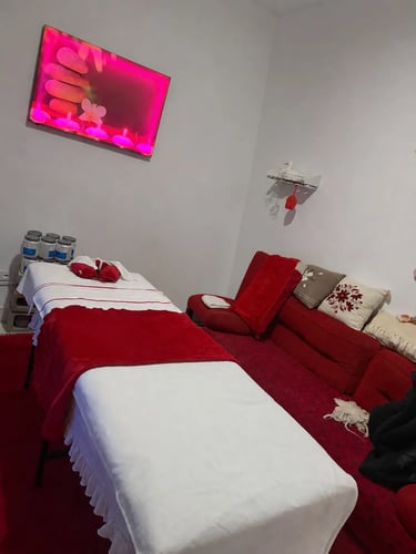 Gabinete de masajes climatizado con camilla profesional y ambientación en tonos rojos en San Isidro.