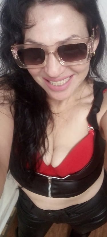 Selfie sonriente de la masajista profesional Dana luciendo anteojos de sol en Tribunales.