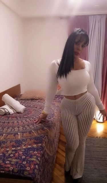 Masajista Kiara con top blanco y pantalón en su cómodo espacio de atención en Caballito.