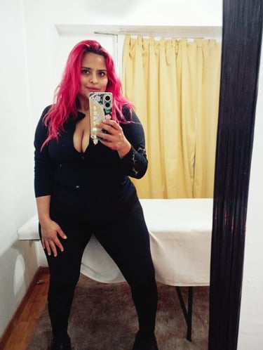 Jessica, masajista sensual en Ramos Mejía, posando frente al espejo de su gabinete equipado con camilla para masajes.