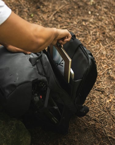 pessoa organizando uma mochila na natureza