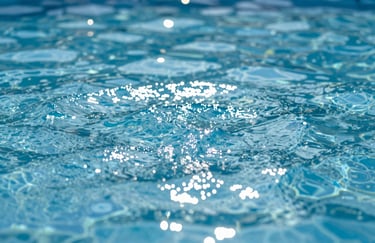 Clean, sparkling pool water surface with bright sunlight reflecting, symbolizing hygiene and perfect maintenance.
