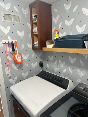 Finished DIY sponge-stamped accent wall in small laundry room
