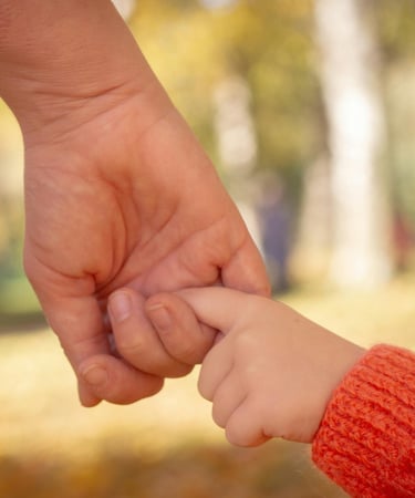 A worried mom holding her child’s hand before pediatric surgery