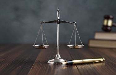 A symbolic image of a silver scale of justice and a gold fountain pen resting on a dark wood surface, representing legal precision. Hints of #2A405D in the background shadows.