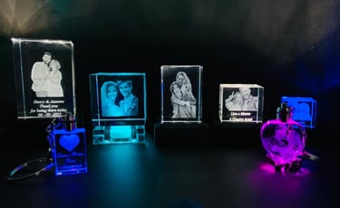 Custom 3D laser engraved photo crystals and keychains with personalized portraits and dates.