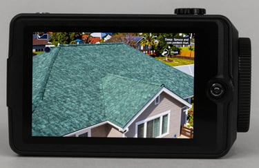 A high-tech thermal imaging camera screen displaying a home's roof, showing solid Deep Spruce and Dusty Sage colors, indicating perfect heat retention.