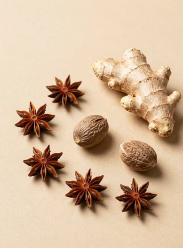 An elegant flat lay of star anise, nutmeg, and ginger on a minimalist tan surface, showcasing variety.