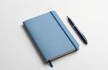 A minimalist Cloud White desk featuring a Soft Azure notebook and a Midnight Navy pen, clean professional aesthetic, overhead shot, soft lighting.