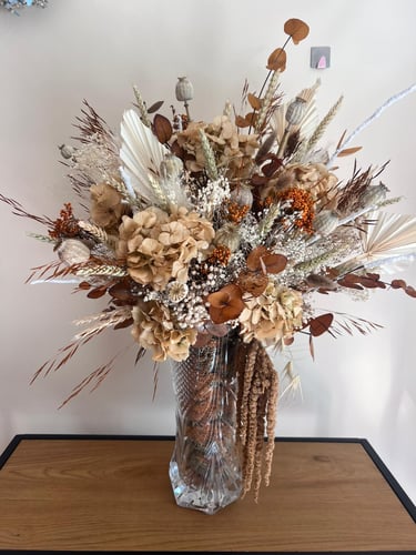 Centro de mesa com arranjo de flores secas em tons neutros para decoração