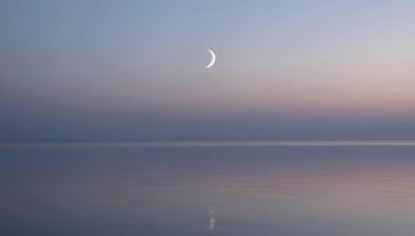 A person practicing a serene yoga pose on a terrace at twilight, silhouette against a soft #AABEC6 sky.