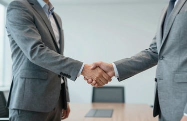 Two professionals shaking hands in a Global / Corporate boardroom, demonstrating trust and long-term client relationships. Accents of light blue-grey.