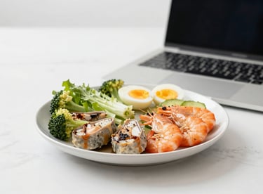 A healthy professional meal next to a laptop, representing M5: The integration of Mental and Physical health for performance.