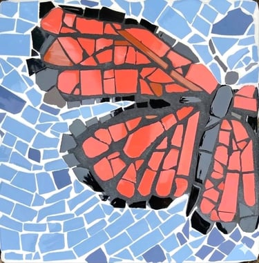 Mosaic stepping stone of a Monarch butterfly hand pieced with ceramic tiles by Julie Curson