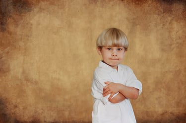 Young boy with cheeky expression arms crossed in studio portrait, Perth children's photographer Fisher Photography