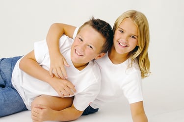 Primary school age brother and sister laughing in studio portrait, Perth children's photographer Fisher Photography