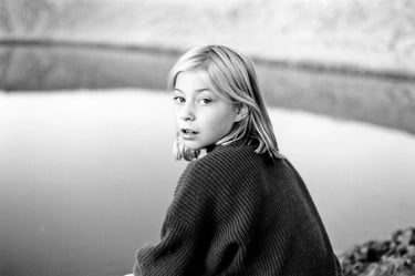Young girl sits beside a dam portrait by Fisher Photography