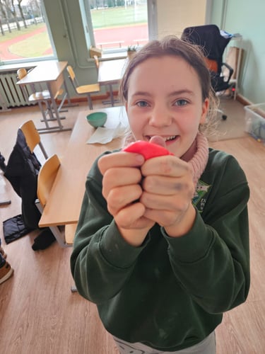 mergaitė rodo būrelio metu pagamintą slaimą