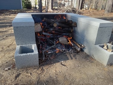 Burning wood and logs in a cement block open fire pit