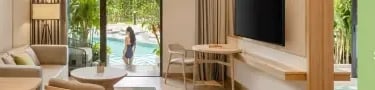 Luxury hotel suite at Dusit Princess with a pool view, modern furniture, and lounge area.