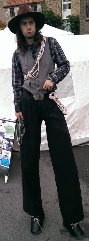 A man in a cowboy hat and western vest holding a lasso rope wild west themed entertainment