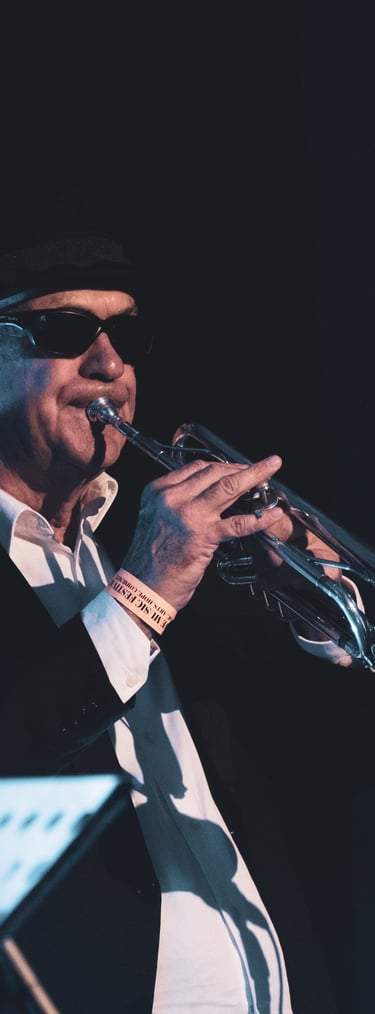a man in a suit and hat playing trumpet