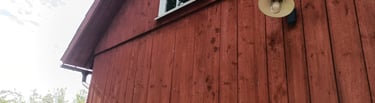 Historic red barn painted with iron oxide and linseed oil — traditional breathable barn paint that fades instead of peeling