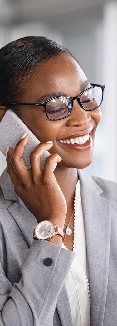 Christian translation services wearing glasses talking on a smartphone in a bright office.