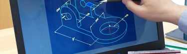Engineer pointing at a 3D mechanical CAD blueprint on a laptop screen for product design.