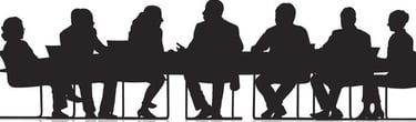 Silouhettes of people sitting at a conference table