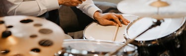a man in a tie and tie shirt playing drums
