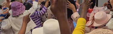 a group of women in hats and hands lifted up
