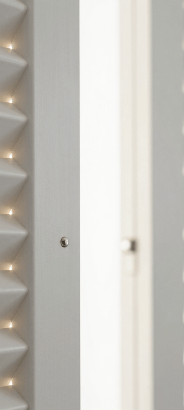 Detail of high-quality white plantation shutters partially open, letting in shards of warm light. Modern, clean aesthetic focusing on the hardware and material quality.