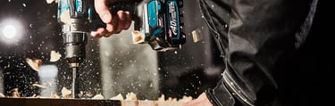 a person using a drillet to drill in a wood