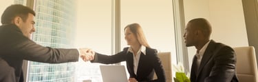 a man and woman shaking hands in a meeting room