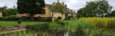 a photo of Willersey village pond with cottages in the background