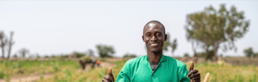 a man in a green shirt and green pants standing in a field