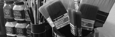 Détail atelier Stanislas Garaud, pinceaux, brosses, pots de pigments purs Sennelier sur cheminée marbre noir